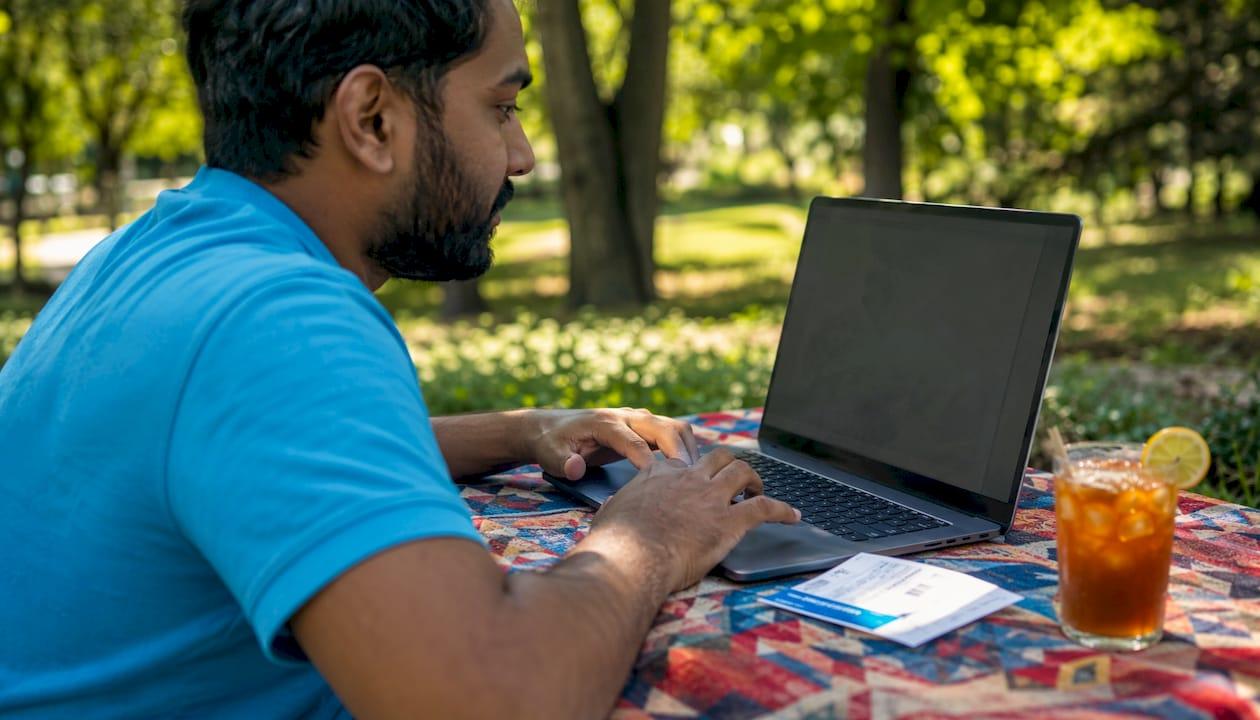 Hands researching airline benefits on laptop